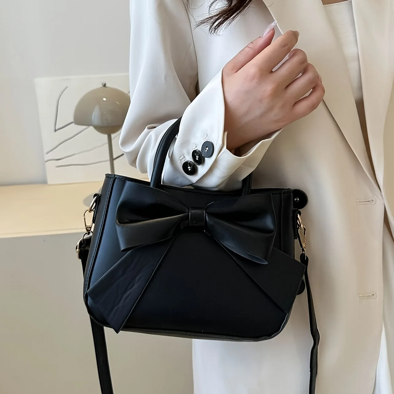 sac à main élégant à nœud noir avec quincaillerie dorée, sangle amovible. polyvalent pour un usage quotidien et les événements formels. mode indispensable! boutique maintenant!
