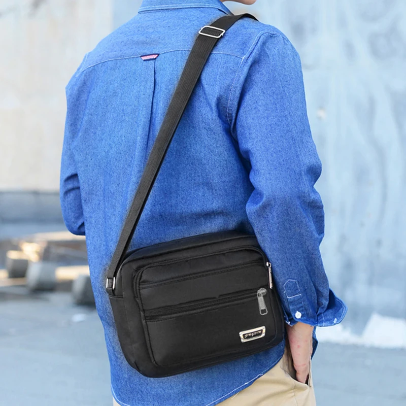 sac d'affaires pour hommes avec deux poches, peut être porté à bandoulière ou au dessus de l'épaule, adapté aux voyages d'affaires.