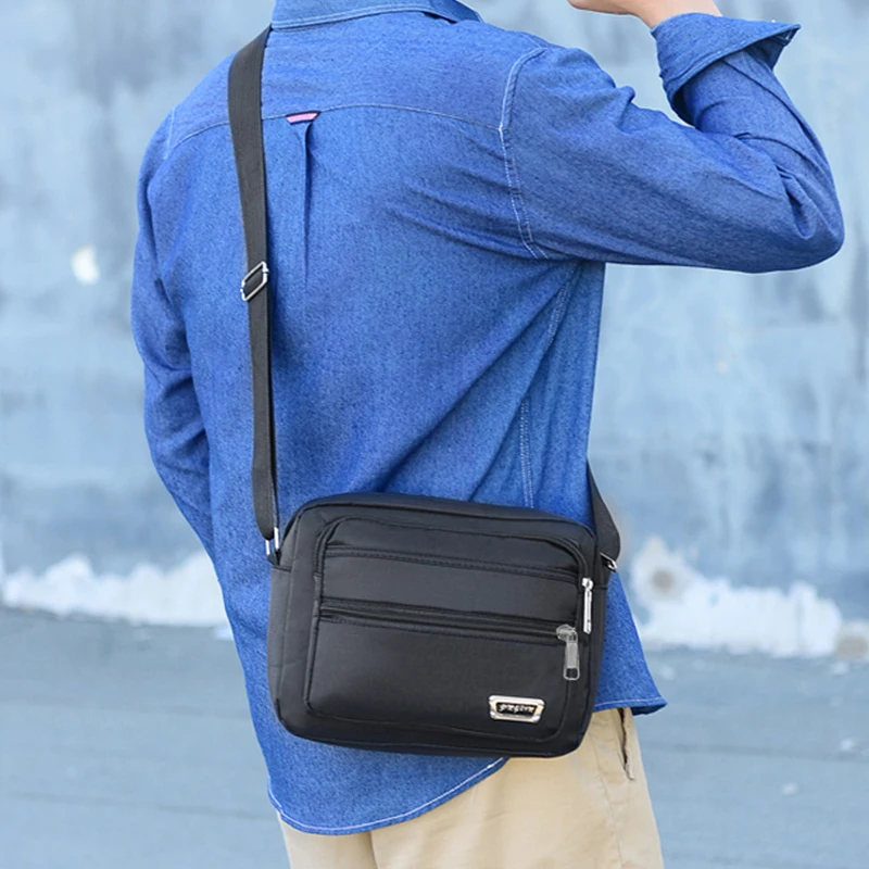 sac d'affaires pour hommes avec deux poches, peut être porté à bandoulière ou au dessus de l'épaule, adapté aux voyages d'affaires.