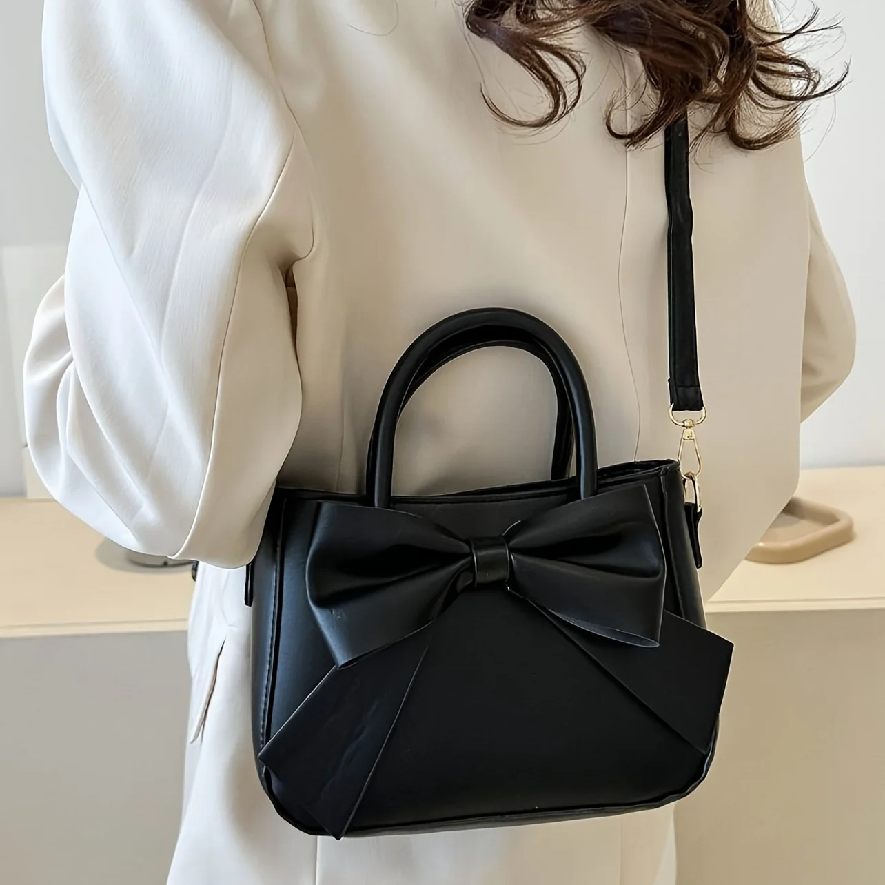 sac à main élégant à nœud noir avec quincaillerie dorée, sangle amovible. polyvalent pour un usage quotidien et les événements formels. mode indispensable! boutique maintenant!