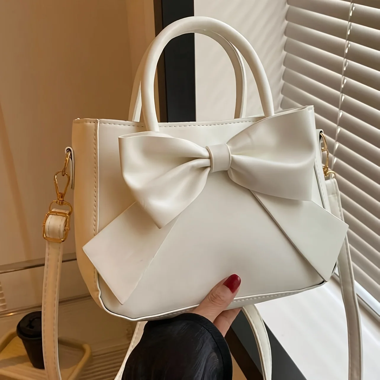 sac à main élégant à nœud noir avec quincaillerie dorée, sangle amovible. polyvalent pour un usage quotidien et les événements formels. mode indispensable! boutique maintenant!