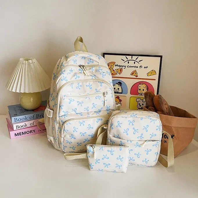 sac dos polyester motifs nœuds rose clair blanc noir bandoulière poignées latérales voyage scolaire femmes