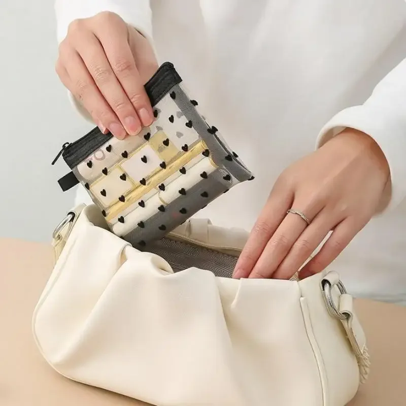 sac de maquillage en maille transparente avec imprimé cœur noir, fermeture éclair lisse, organisateur de cosmétiques léger pour les vacances et la salle de bain.