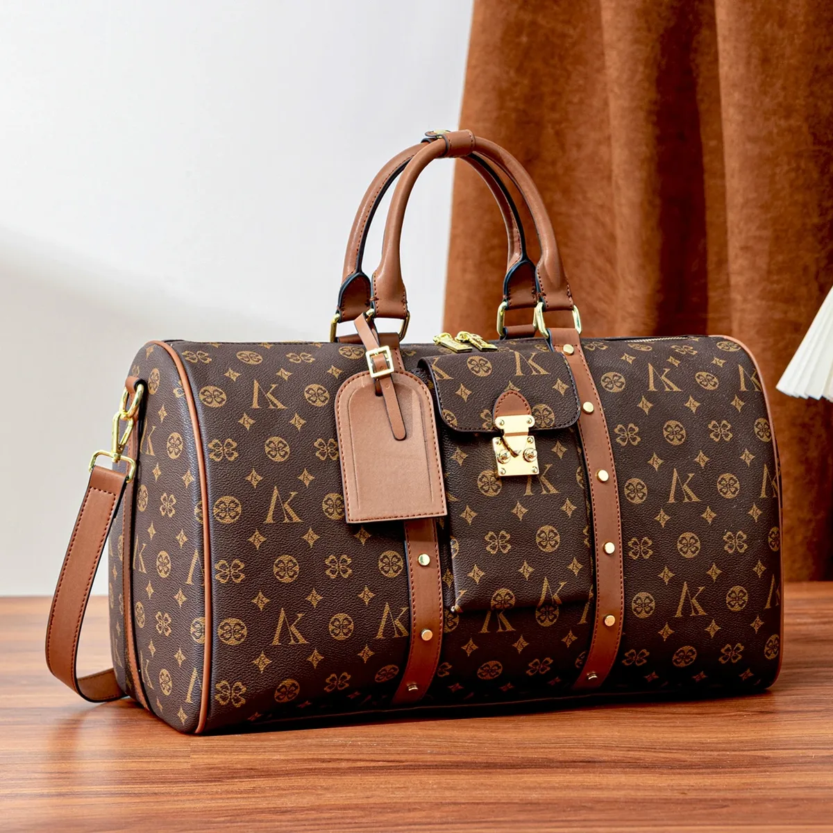 sac de voyage marron à motif monogramme, anses supérieures, bandoulière réglable, poche avant et détails dorés