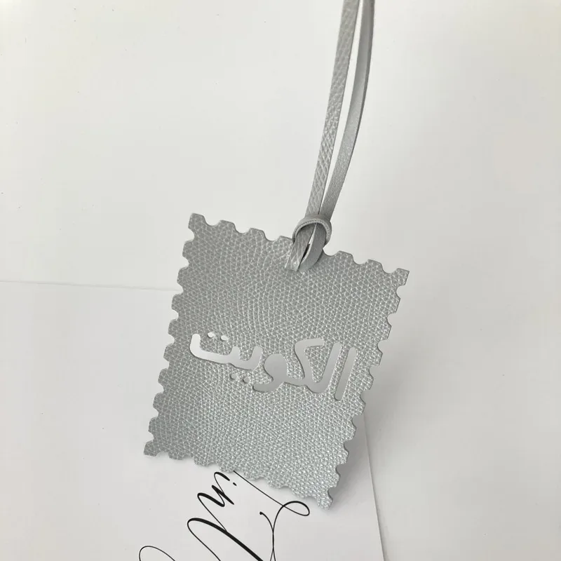 étiquette bagage imitation cuir motif dentelé couleur multiple texte arabes voyage identité valises nom adresse