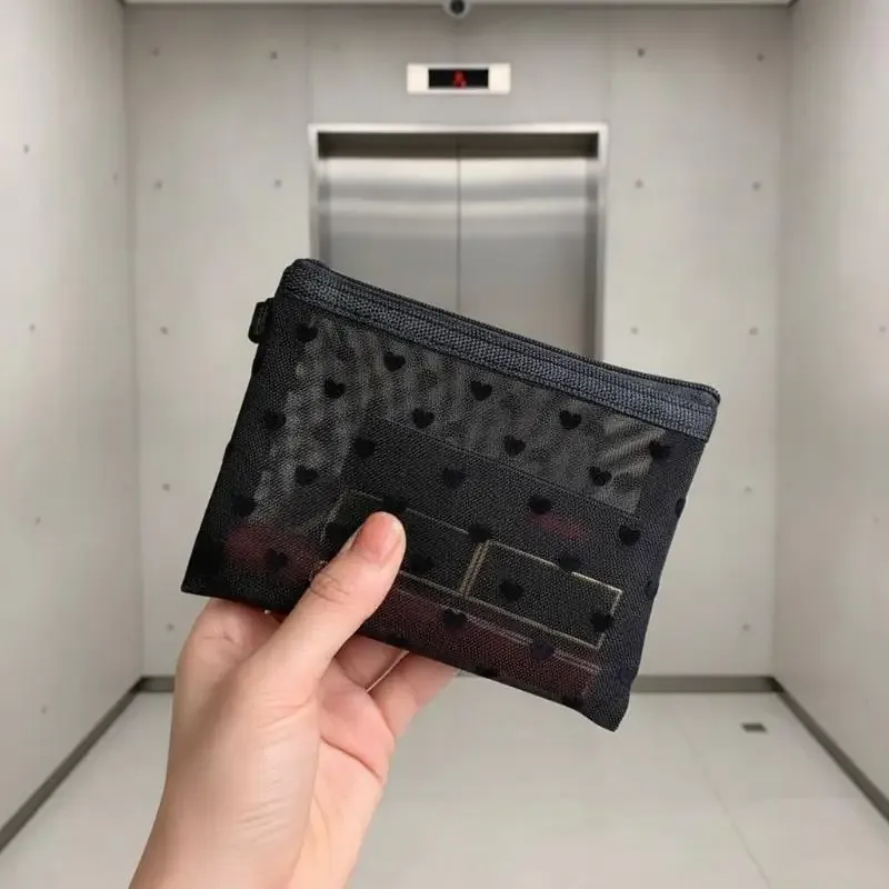 sac de maquillage en maille transparente avec imprimé cœur noir, fermeture éclair lisse, organisateur de cosmétiques léger pour les vacances et la salle de bain.