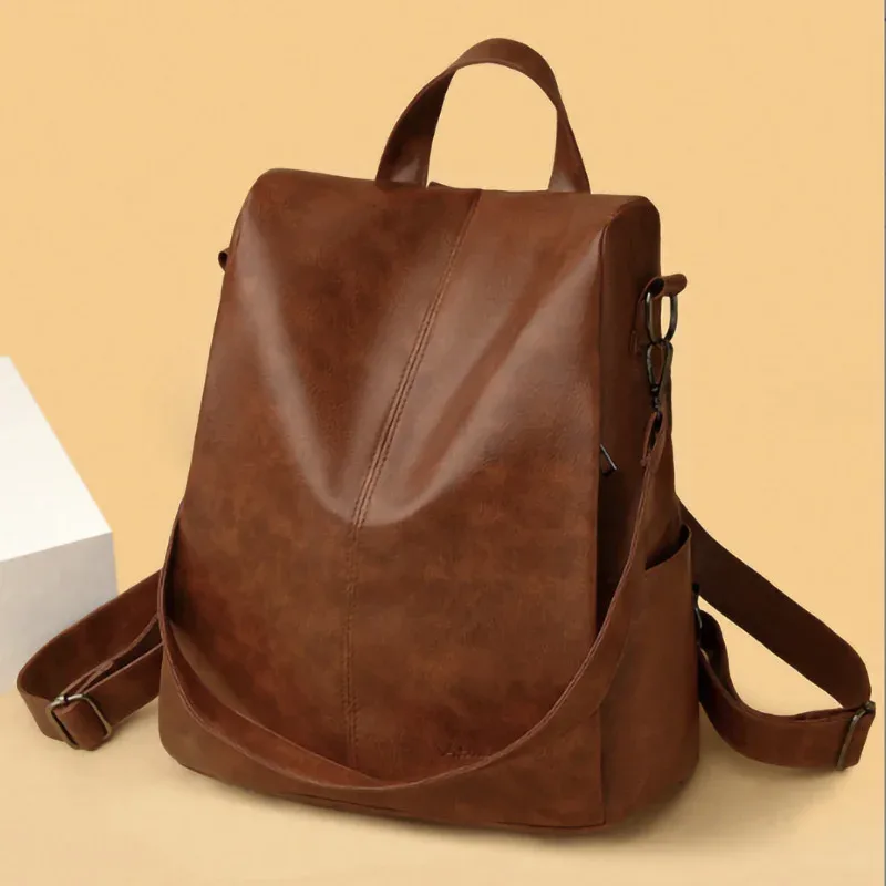 sac dos cuir matériau similaire marron clair texture grunge forme trapézoïdale poignées latérales sangle ajustable voyage femme