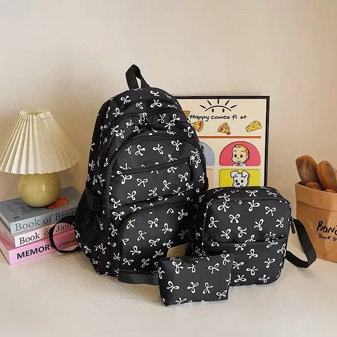 sac dos polyester motifs nœuds rose clair blanc noir bandoulière poignées latérales voyage scolaire femmes