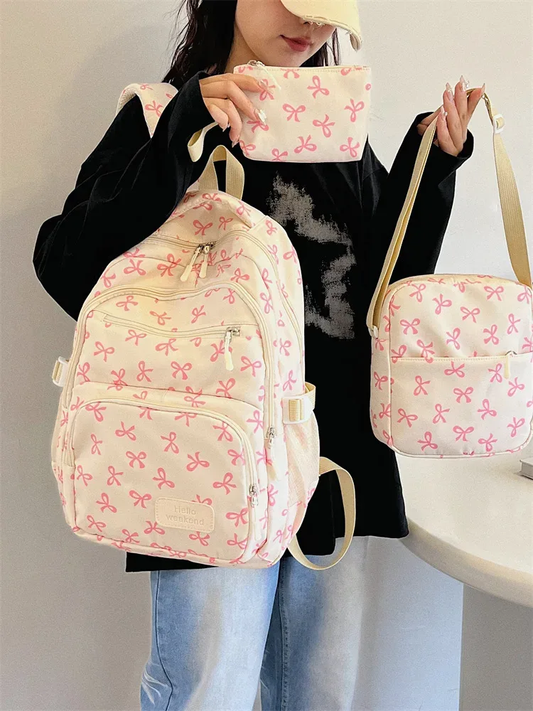 sac dos polyester motifs nœuds rose clair blanc noir bandoulière poignées latérales voyage scolaire femmes
