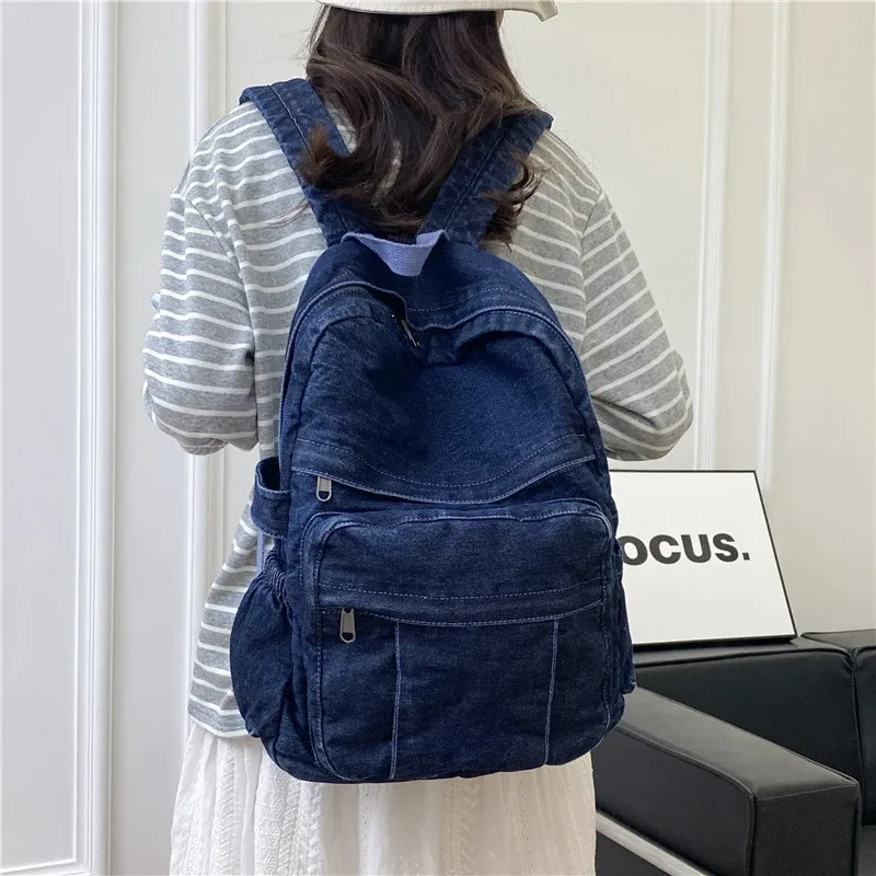 sac dos jean bleu denim cuir marron poche avant zippée bandoulières souplement détendu usage voyage école quotidien transport ordinateur portable