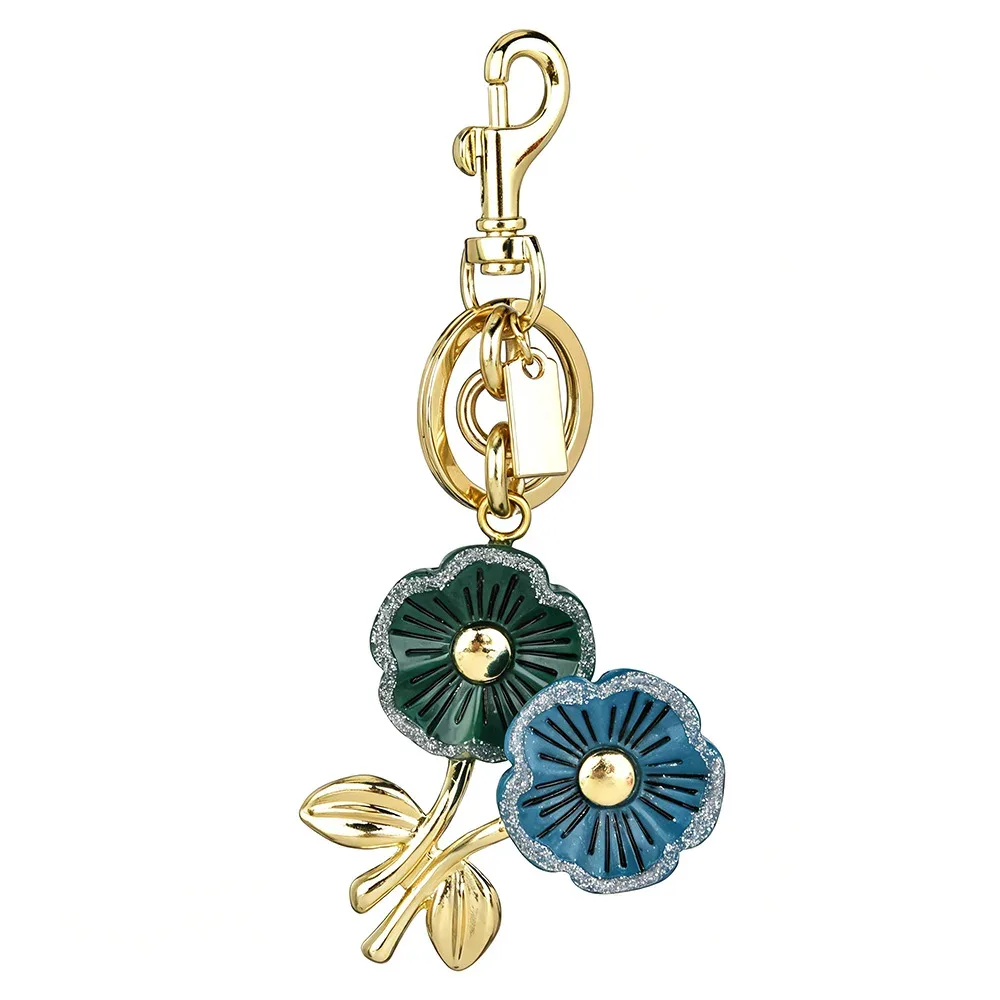sac dos ornementation fleurs vertes bleues anneau doré pétales brillants feuilles vertes accessoire voyage chic vintage
