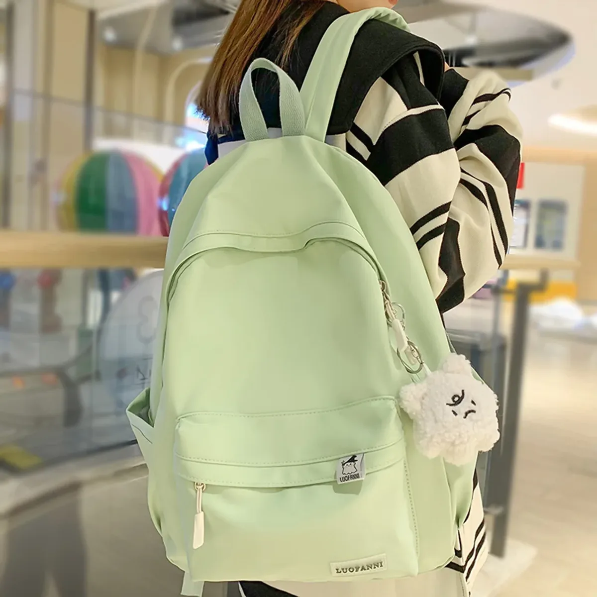 sac dos nylon imperméable vert pastel rouge beige noir poche avant zippée pomponneuse blanche bandoulière arquée usage voyage