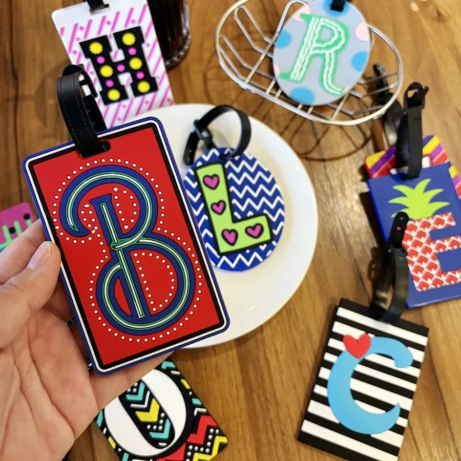 étiquette bagage pvc lettres relief forme rectangulaire ovale motifs zigzags cœurs géométriques couleurs bleu vert rouge noir blanc voyage identification anti-perte