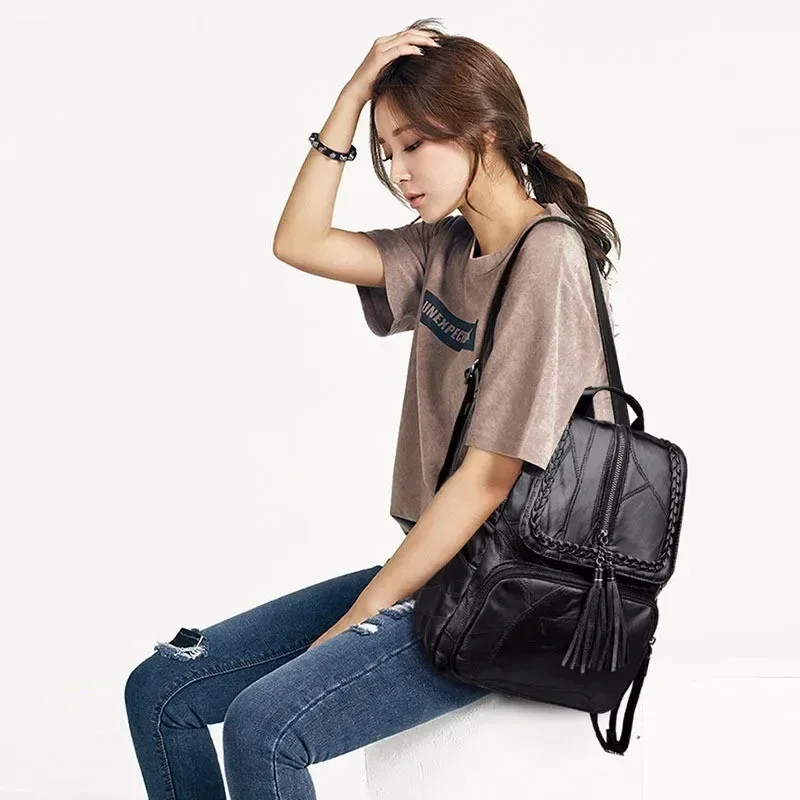 sac dos cuir noir bandoulière arquée fermeture éclair poches lateral pompon decoratif usage voyage polyvalent