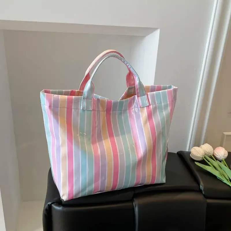 ce sac fourre-tout en pvc résistant à l'eau présente un motif rayé rose et bleu, une grande capacité et convient pour faire du shopping à la plage.