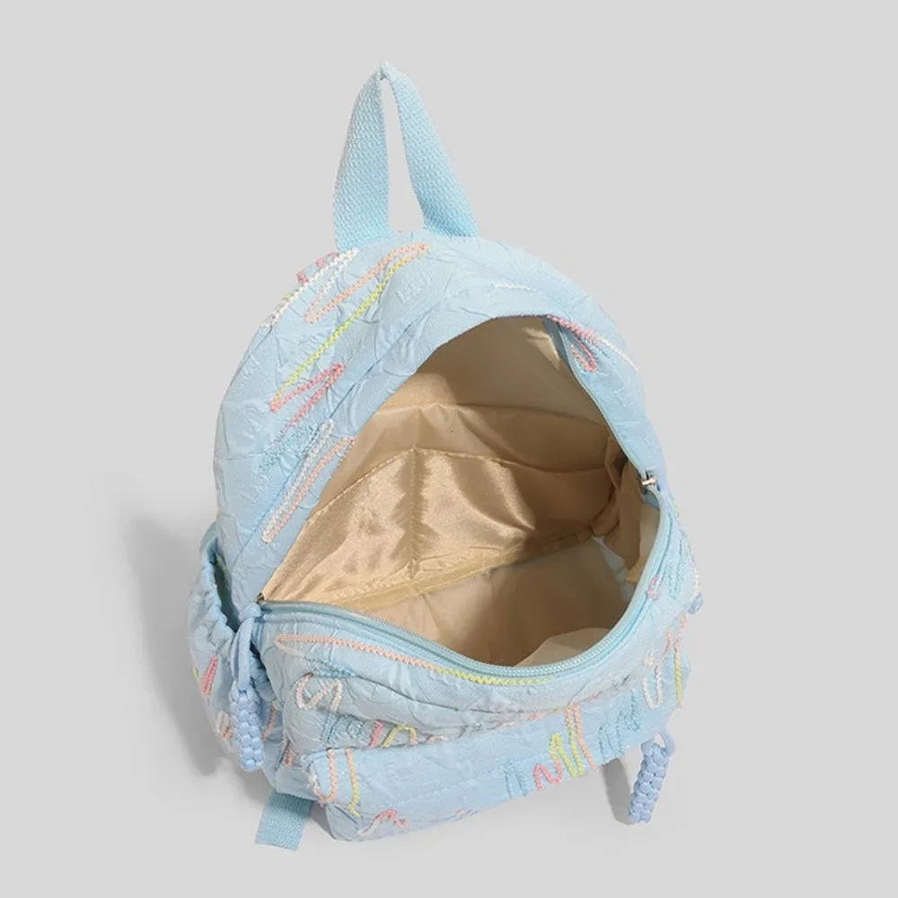 sac dos nylon motif ondulé légèrement matte lacet reglable fermeture éclair petite capacité voyage femme bleu noir beige