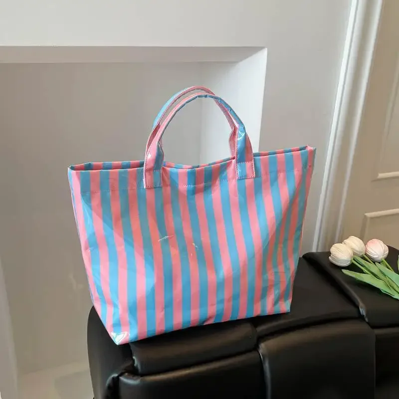 ce sac fourre-tout en pvc résistant à l'eau présente un motif rayé rose et bleu, une grande capacité et convient pour faire du shopping à la plage.