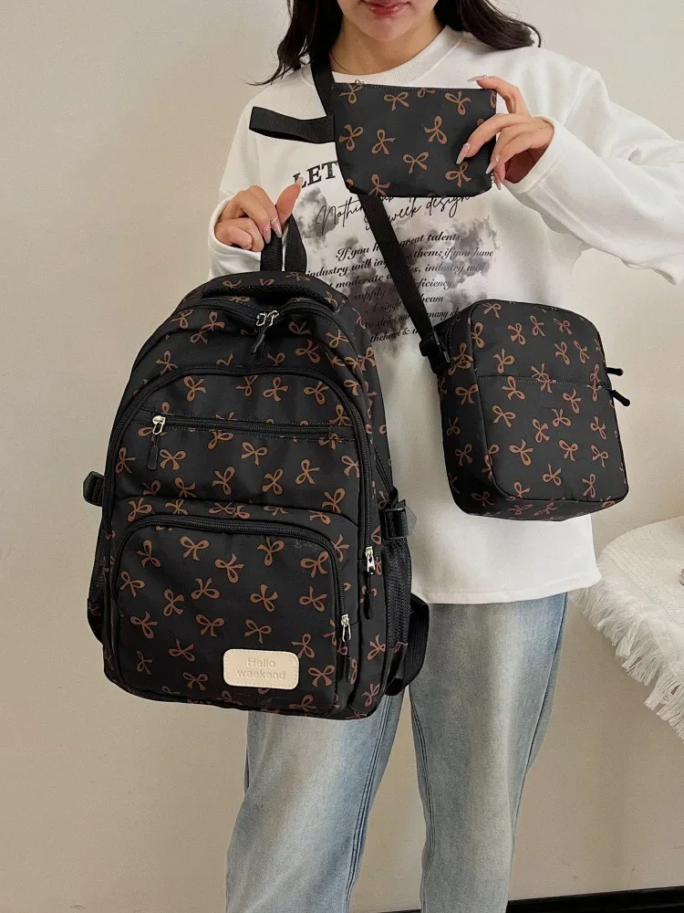 sac dos polyester motifs nœuds rose clair blanc noir bandoulière poignées latérales voyage scolaire femmes