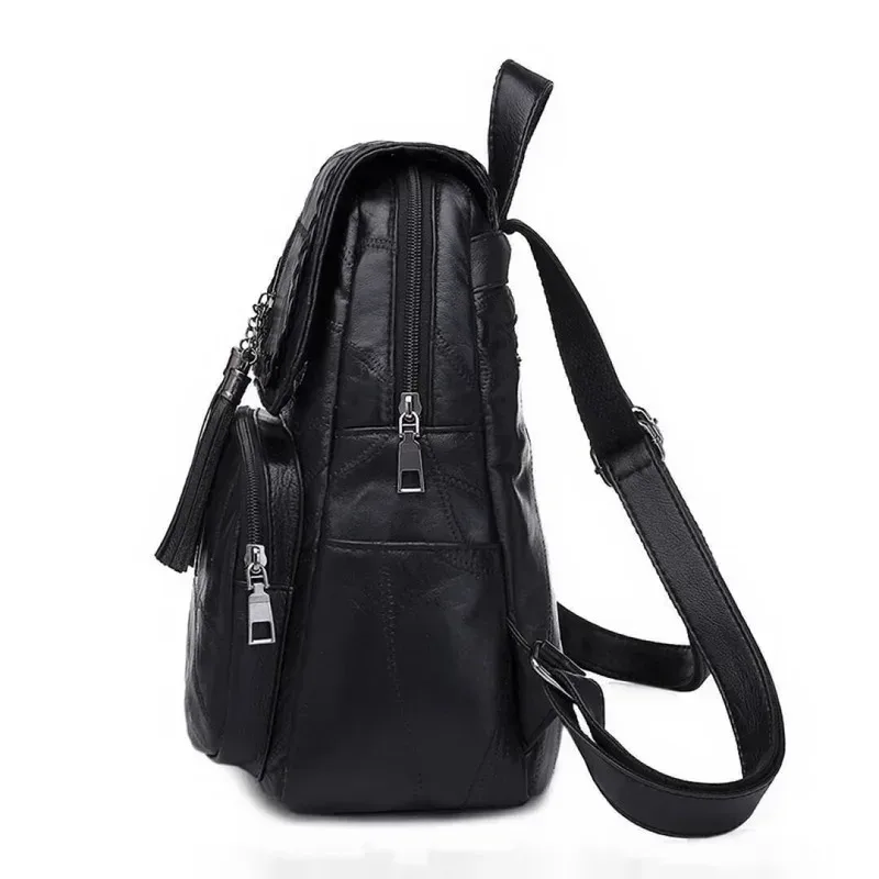 sac dos cuir noir bandoulière arquée fermeture éclair poches lateral pompon decoratif usage voyage polyvalent