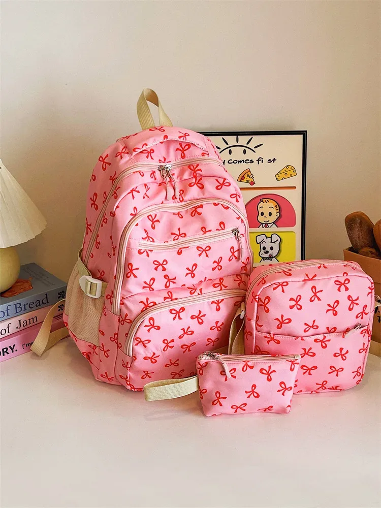 sac dos polyester motifs nœuds rose clair blanc noir bandoulière poignées latérales voyage scolaire femmes