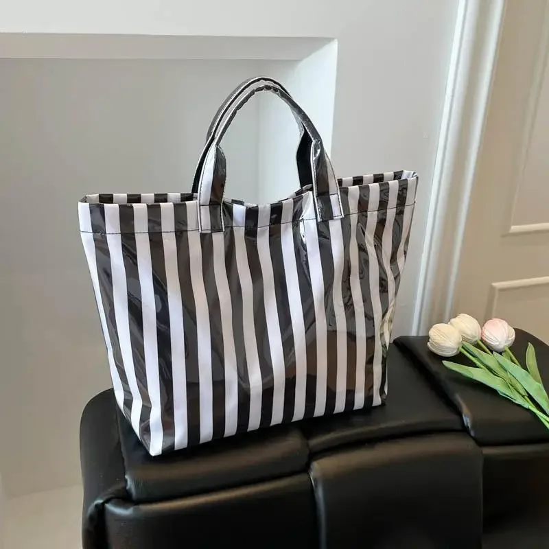 ce sac fourre-tout en pvc résistant à l'eau présente un motif rayé rose et bleu, une grande capacité et convient pour faire du shopping à la plage.