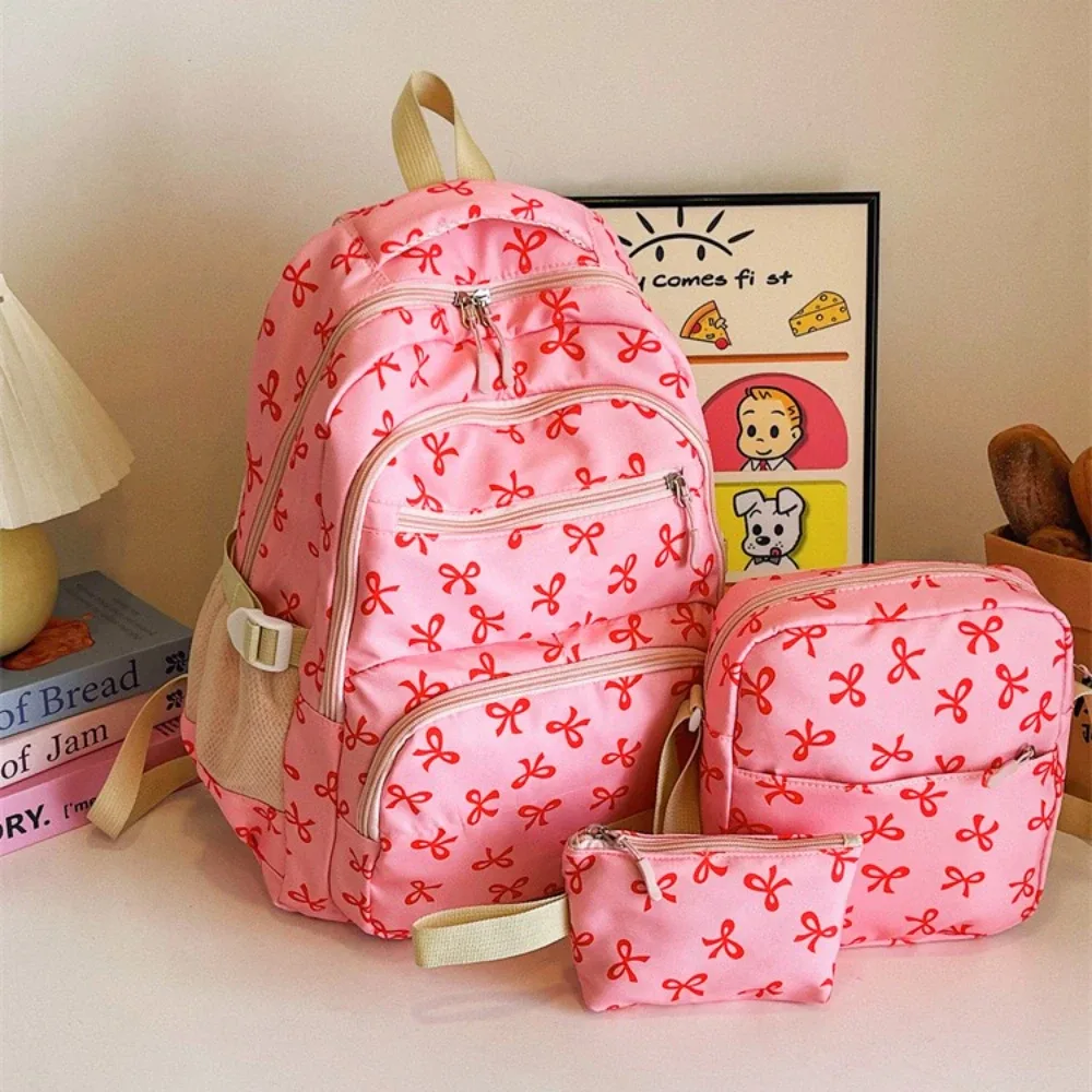 sac dos polyester motifs nœuds rose clair blanc noir bandoulière poignées latérales voyage scolaire femmes