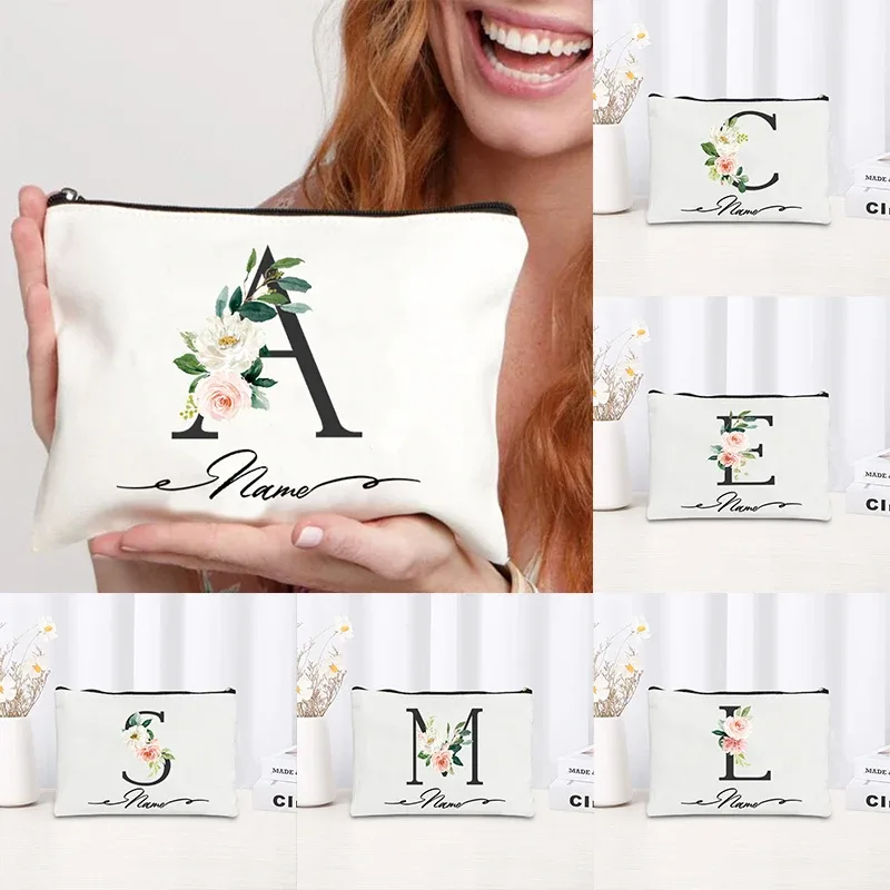 pochette personnalisée en toile noire à motif floral avec initiale en écriture cursive, trousse de toilette fine et compacte pour femmes, idéale pour les voyages et l'usage quotidien.