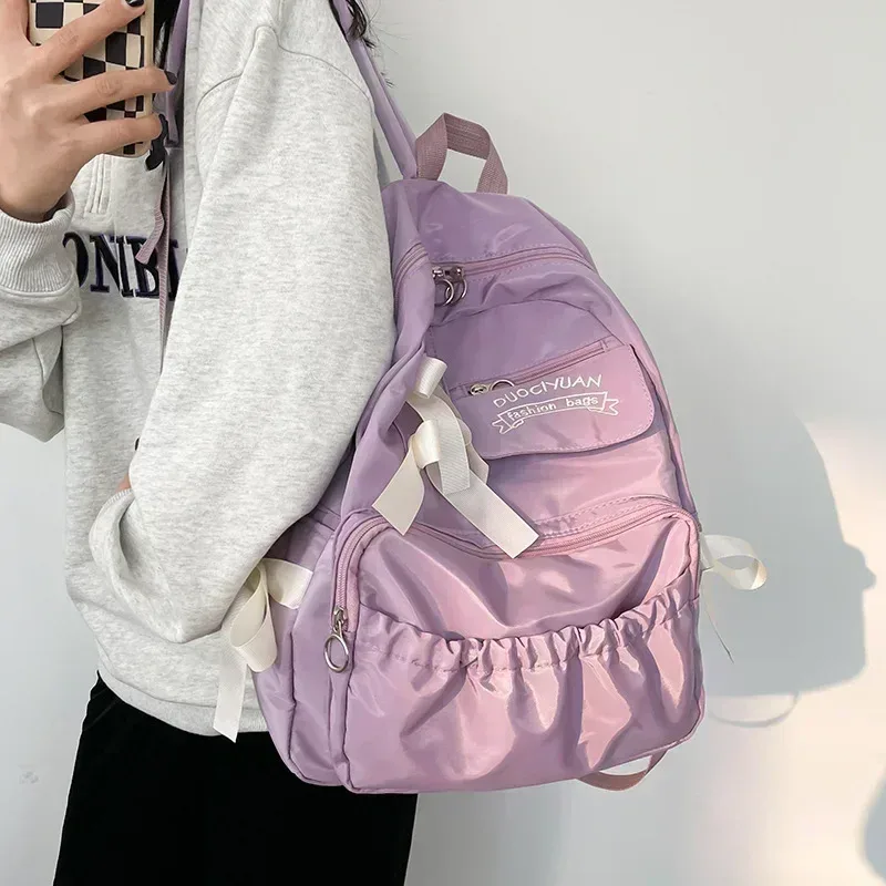 sac dos nylon beige poche ouverte fermeture éclair style preppy arc décoration usage voyage école adolescente femmes