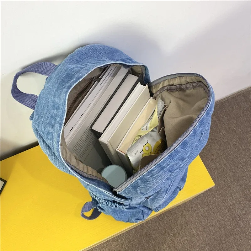 sac dos jean bleu denim cuir marron poche avant zippée bandoulières souplement détendu usage voyage école quotidien transport ordinateur portable