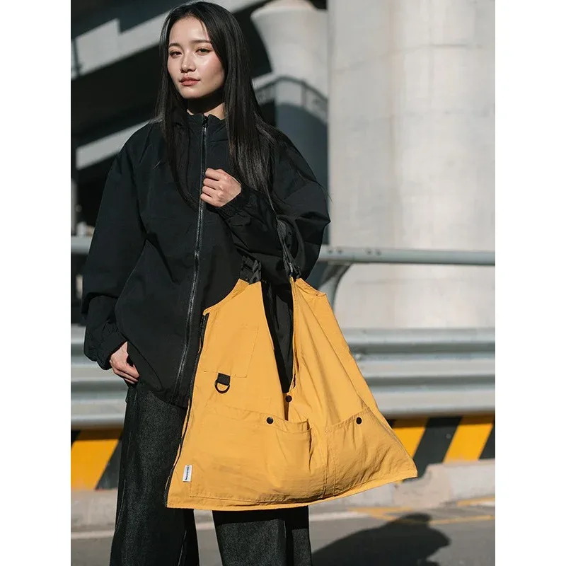 sac dos nylon jaune vert rose poches ouvertes bandoulière arquée fermeture éclair capacité inferieure deuxize litres usage voyage décontracté jacquard