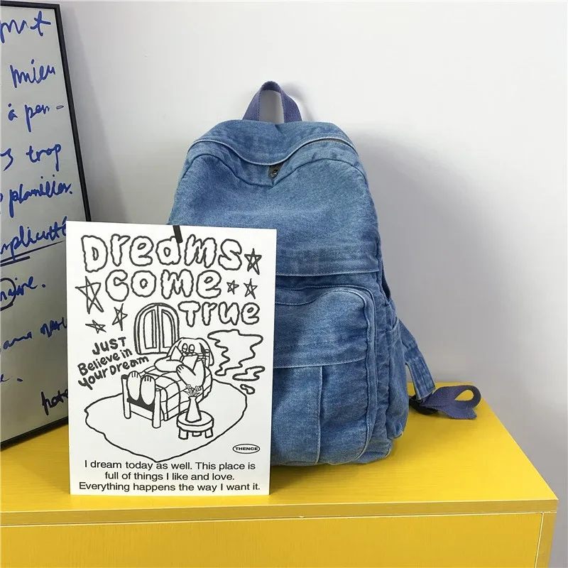 sac dos jean bleu denim cuir marron poche avant zippée bandoulières souplement détendu usage voyage école quotidien transport ordinateur portable