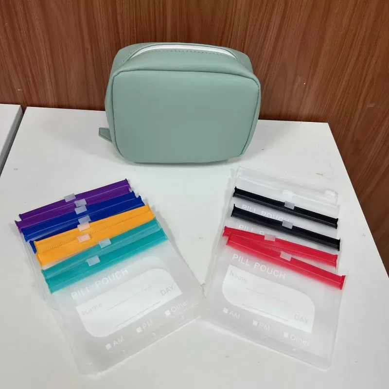 organisateur voyage pilules pochettes transparents bandes couleur assortie boîte vert pastel fermeture glissière noire imperméable