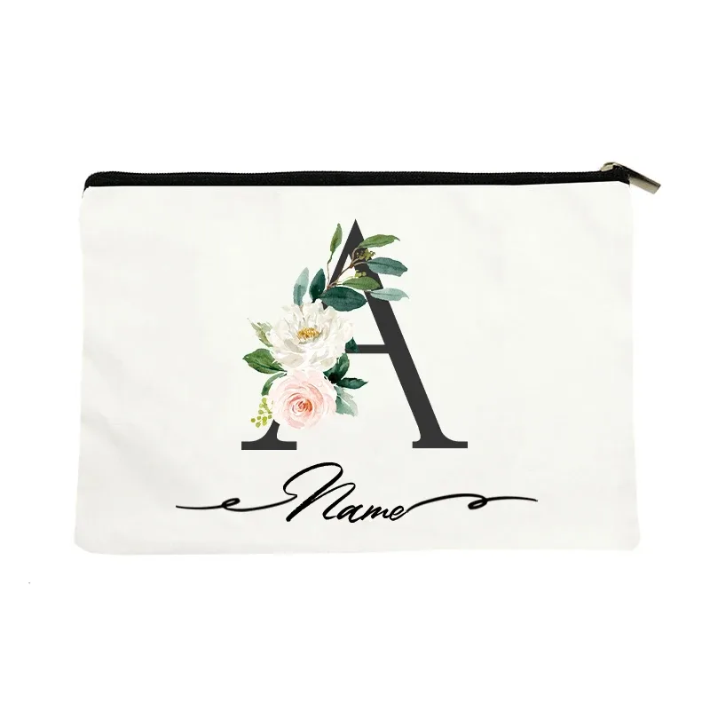 pochette personnalisée en toile noire à motif floral avec initiale en écriture cursive, trousse de toilette fine et compacte pour femmes, idéale pour les voyages et l'usage quotidien.