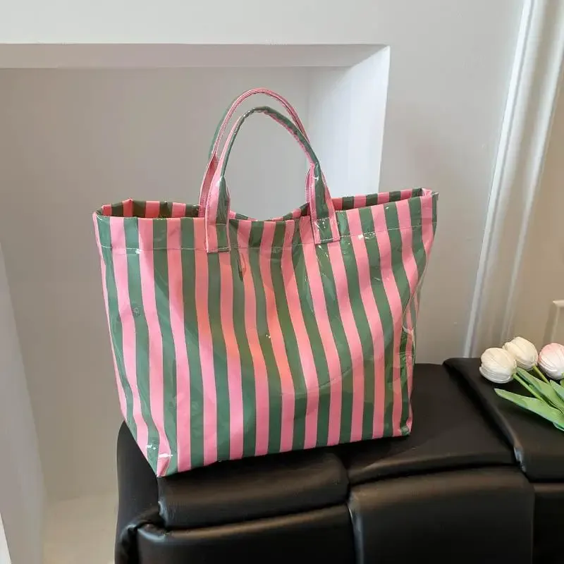 ce sac fourre-tout en pvc résistant à l'eau présente un motif rayé rose et bleu, une grande capacité et convient pour faire du shopping à la plage.