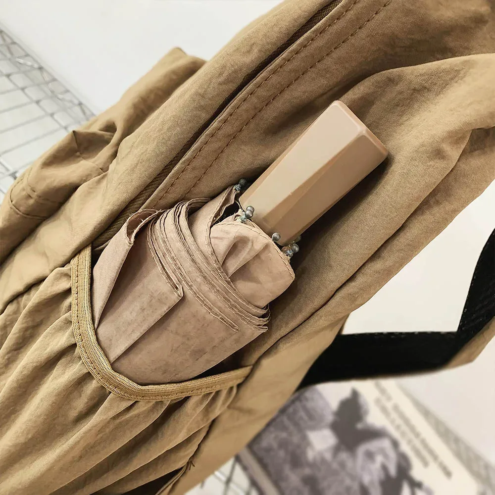 sac dos nylon beige clair pliable grande capacité bandoulière arquée poche intérieure zippée usage voyage décontracté