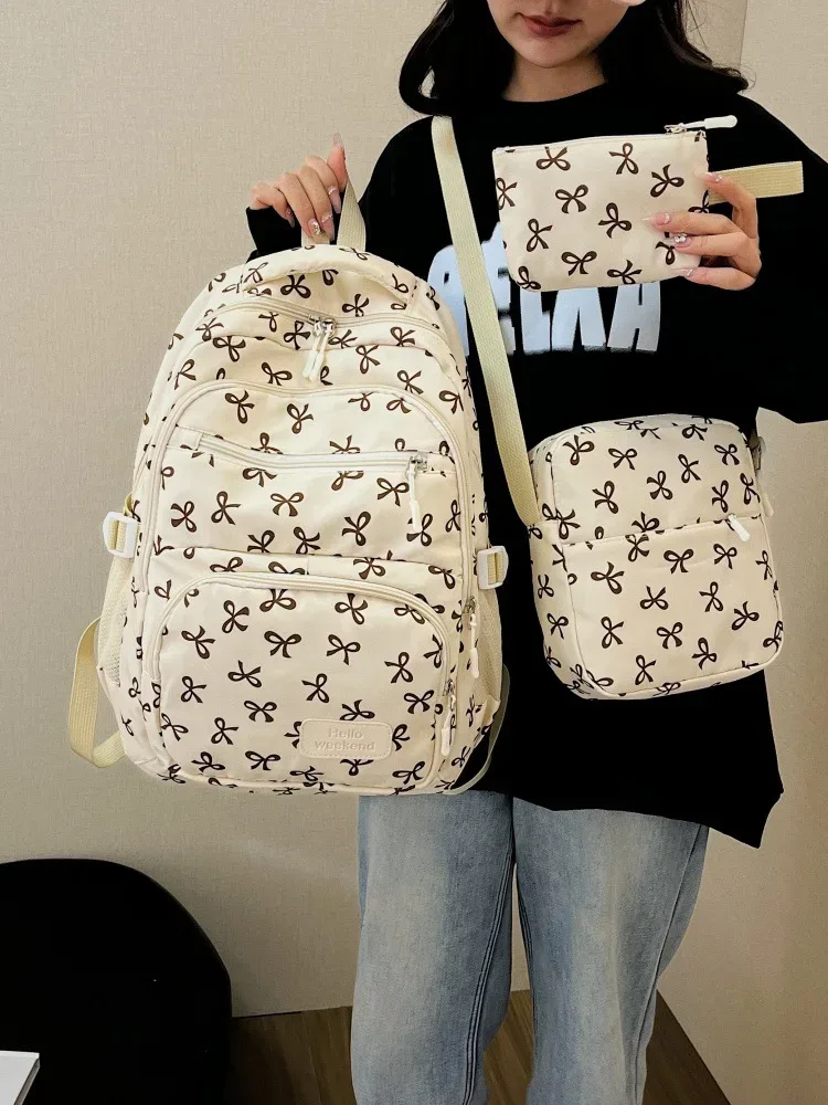 sac dos polyester motifs nœuds rose clair blanc noir bandoulière poignées latérales voyage scolaire femmes