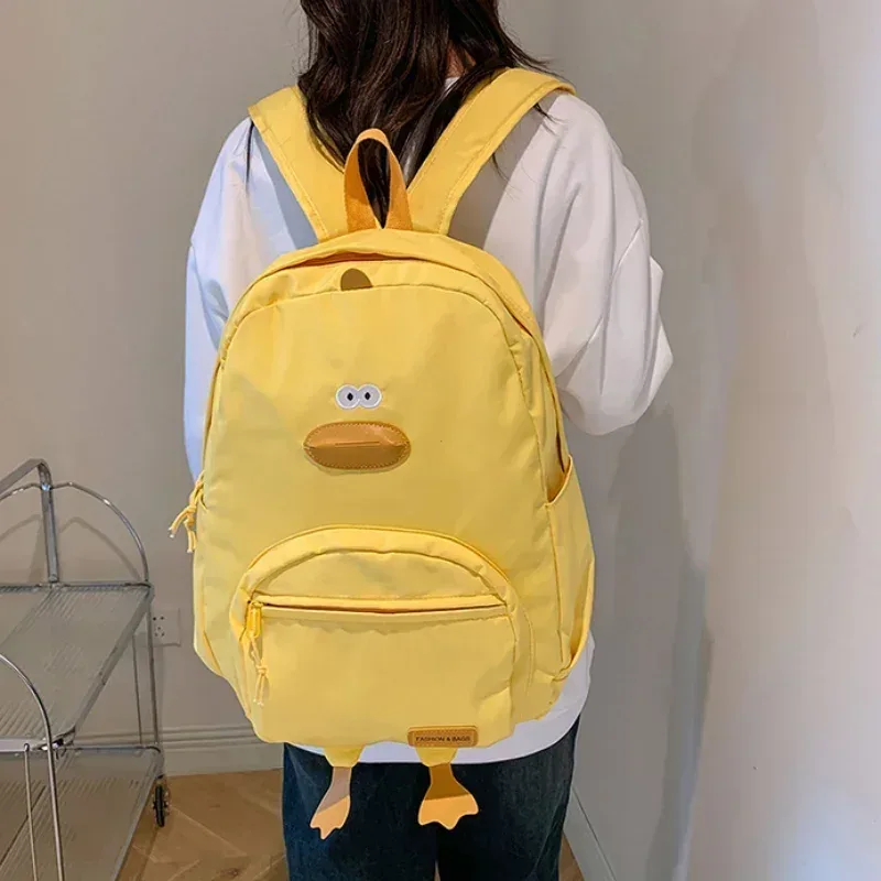 sac dos nylon noir jaune beige forme rectangulaire poignée souple bandoulière arquée fermeture glissière voyage femme étudiant école polyvalent