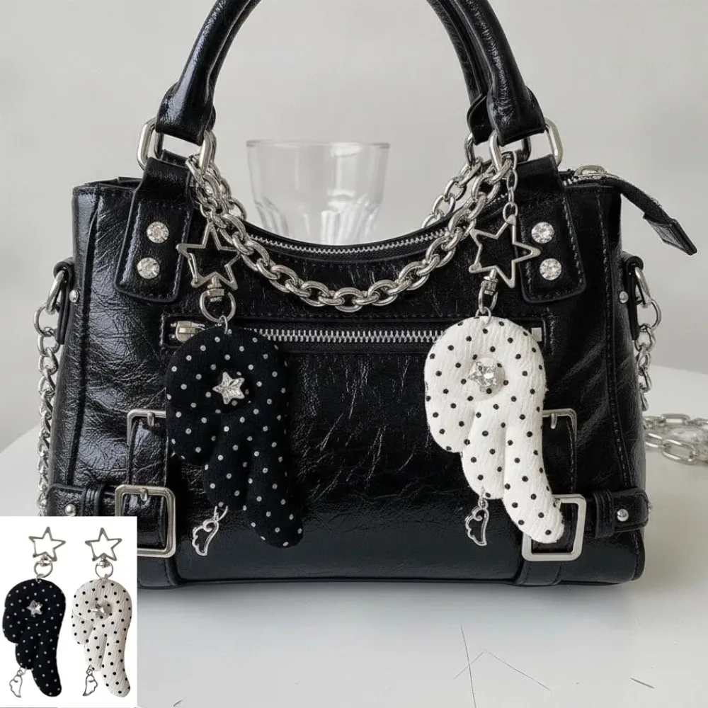 cadenas serrure tsa pochette cuir noir détails métal argent ailes tissu blanc noir pois coeur étoile metallique chaînes
