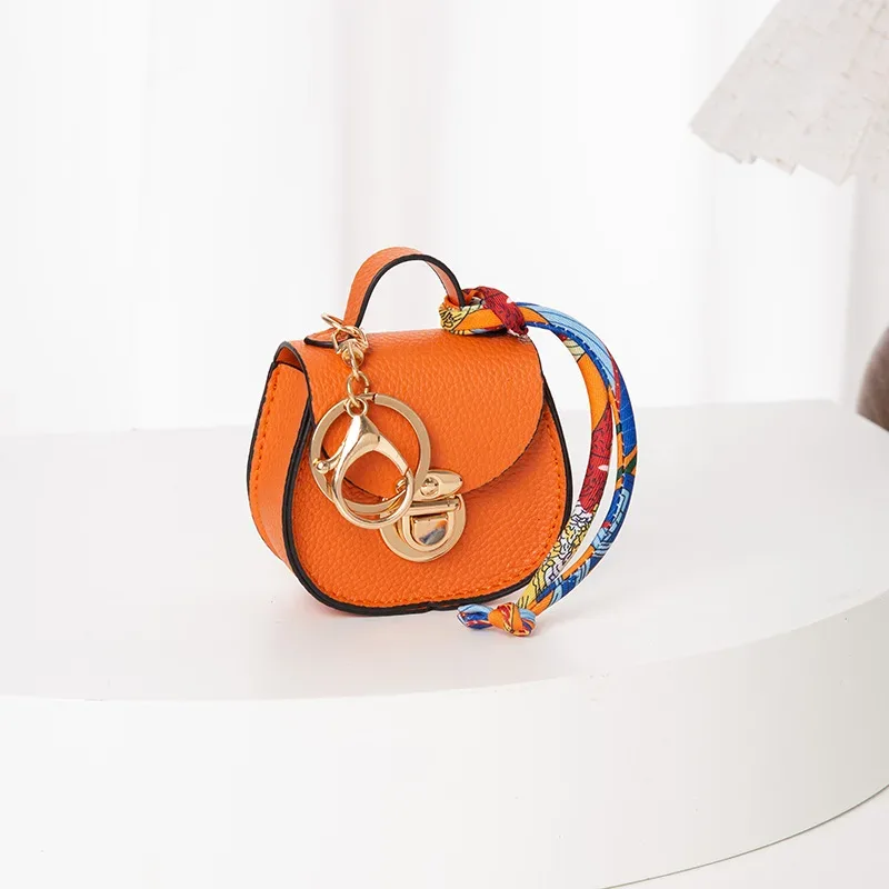 pochette porte-clés multifonctionnelle et portable, tendance et polyvalente, en forme de selle, avec porte-monnaie et étui de rangement pour écouteurs sans fil.