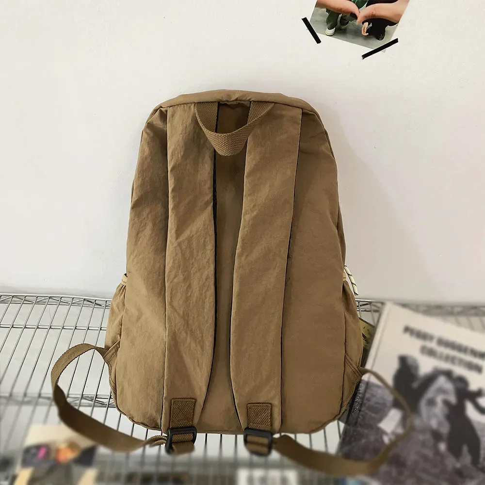 sac dos nylon beige clair pliable grande capacité bandoulière arquée poche intérieure zippée usage voyage décontracté