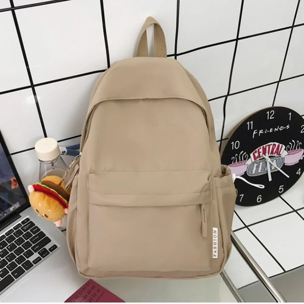 sac dos nylon imperméable rose beige vert pastel noir format rectangulaire poche latérale zippée porte-clés hamburger usage voyage décontracté