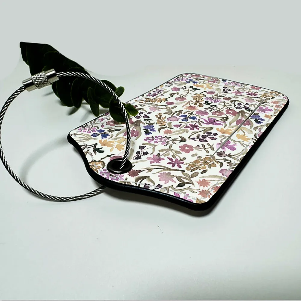 étiquette bagage polyuréthane motif floral subtil fond beige anneau métallique voyage affaires identification nom adresse