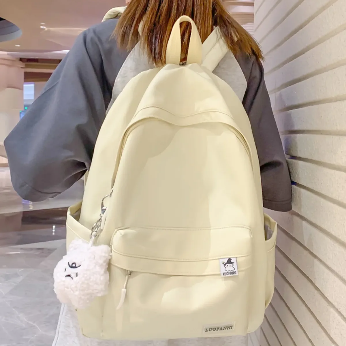 sac dos nylon imperméable vert pastel rouge beige noir poche avant zippée pomponneuse blanche bandoulière arquée usage voyage